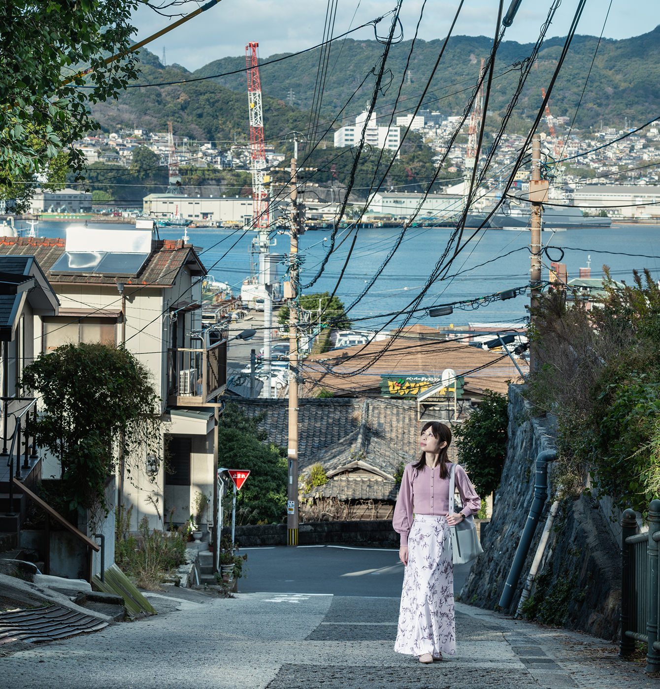 長崎の坂道を登る女性